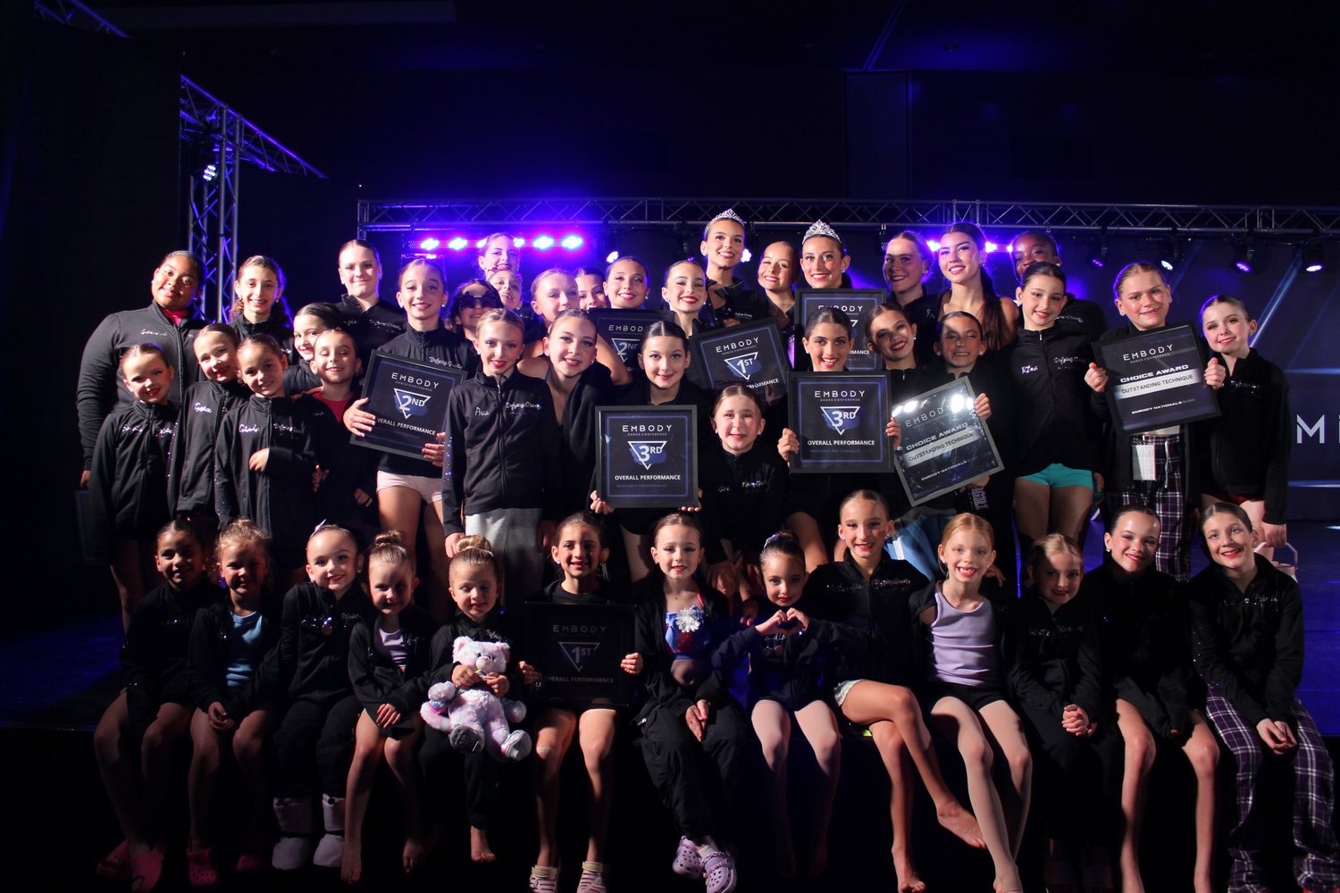 The Defying Gravity team holding Embody award plaques together on stage.