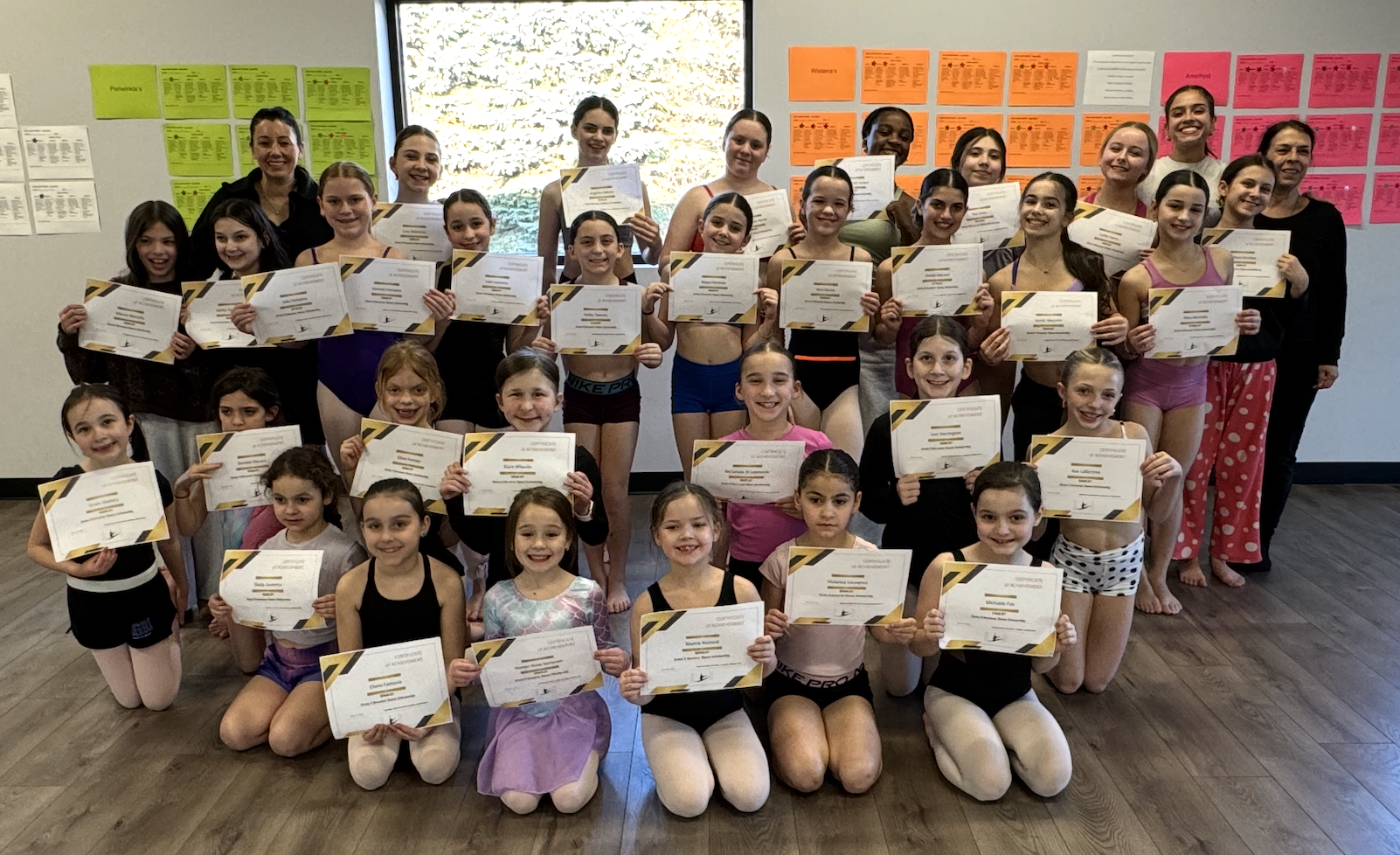 Young scholarship recipients at Defying Gravity School of Dance holding their GRBSF certificates.